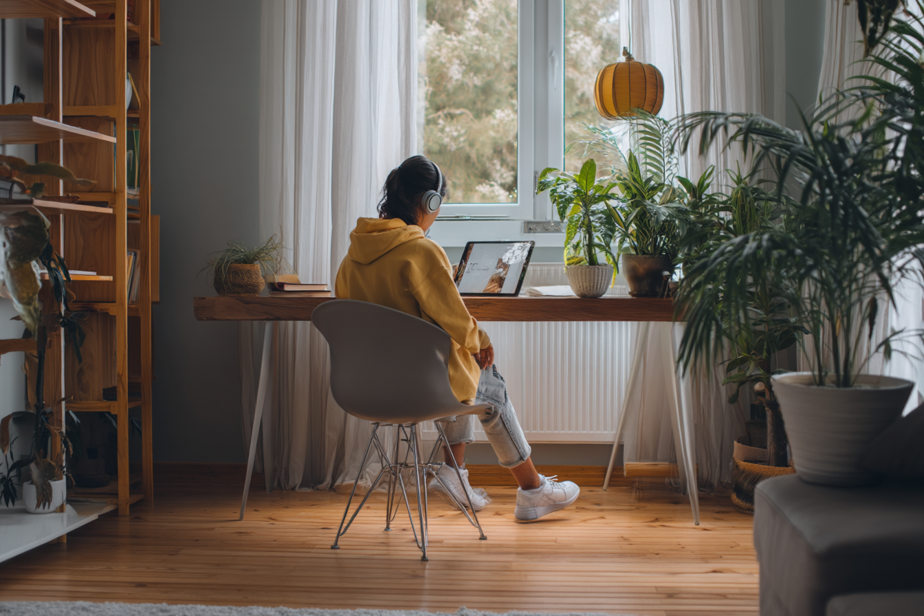 Adulte concentré sur une tablette dans un environnement lumineux et calme, suivant une formation en ligne dans un cadre serein et épuré.
